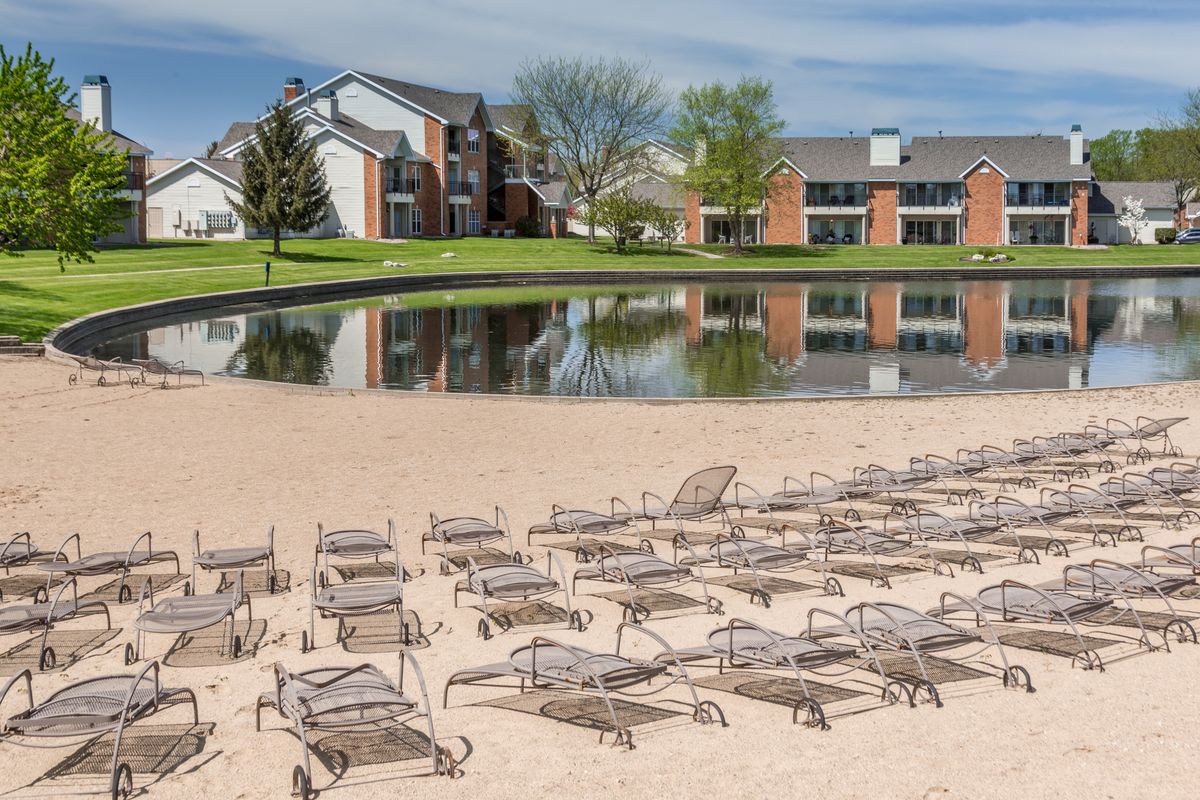Lounge chairs on a sandy beach by the Baytowne lake
