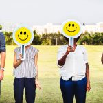 Staff members holding up smilie face signs